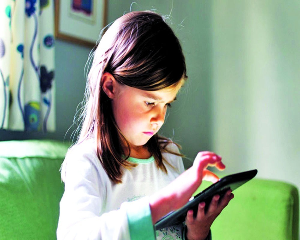 کودک در حال استفاده از گوشی و اینترنت